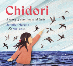 Light blue sky with a darker blue ocean. A girl in red with black hair holding a pencil up as she draws birds onto the sky. The entire image is made of paper, except for the birds with ink.