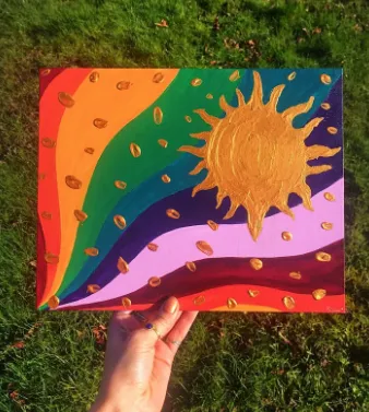 Painting of a gold sun and stars with a rainbow sky