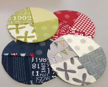 4 different circle coasters each made with 4 different monochromatic fabrics