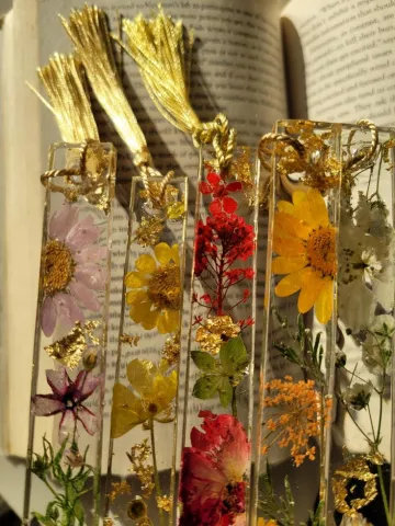An assortment of clear resin bookmarks with pressed flowers inside.