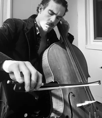 A photogrpah of Ryan Mitten playing the cello