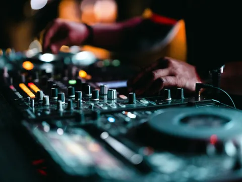 photograph of hands at DJ equipment