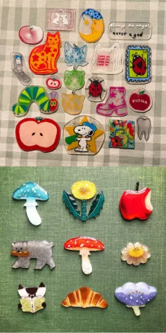 Hand drawn pins of various designs made with shrink plastic.