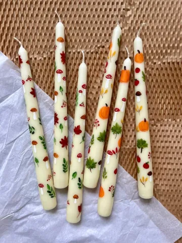 Tall candles painted with Halloween motifs.