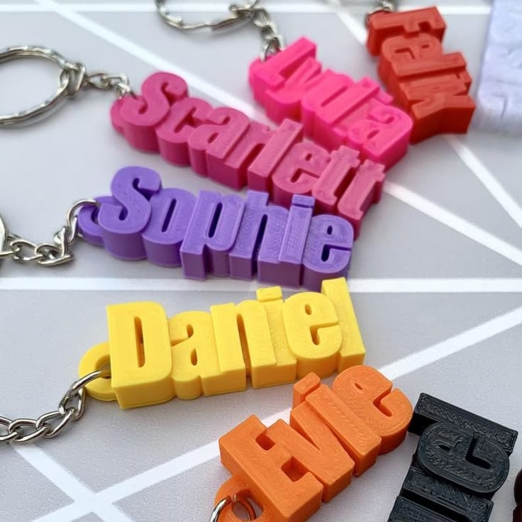 Assortment of 3D printed keychains with different names.