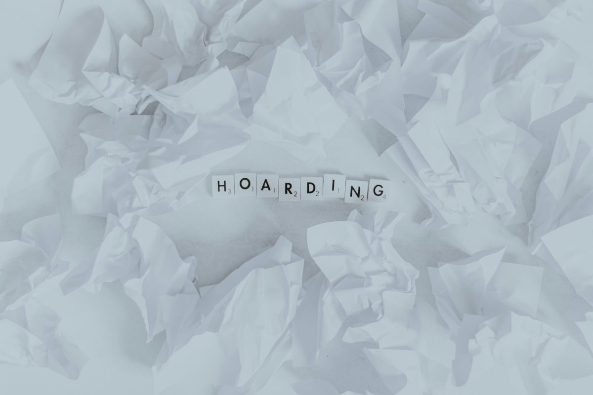 White crumpled paper with the word hoarding in the center spelled with scrabble tiles
