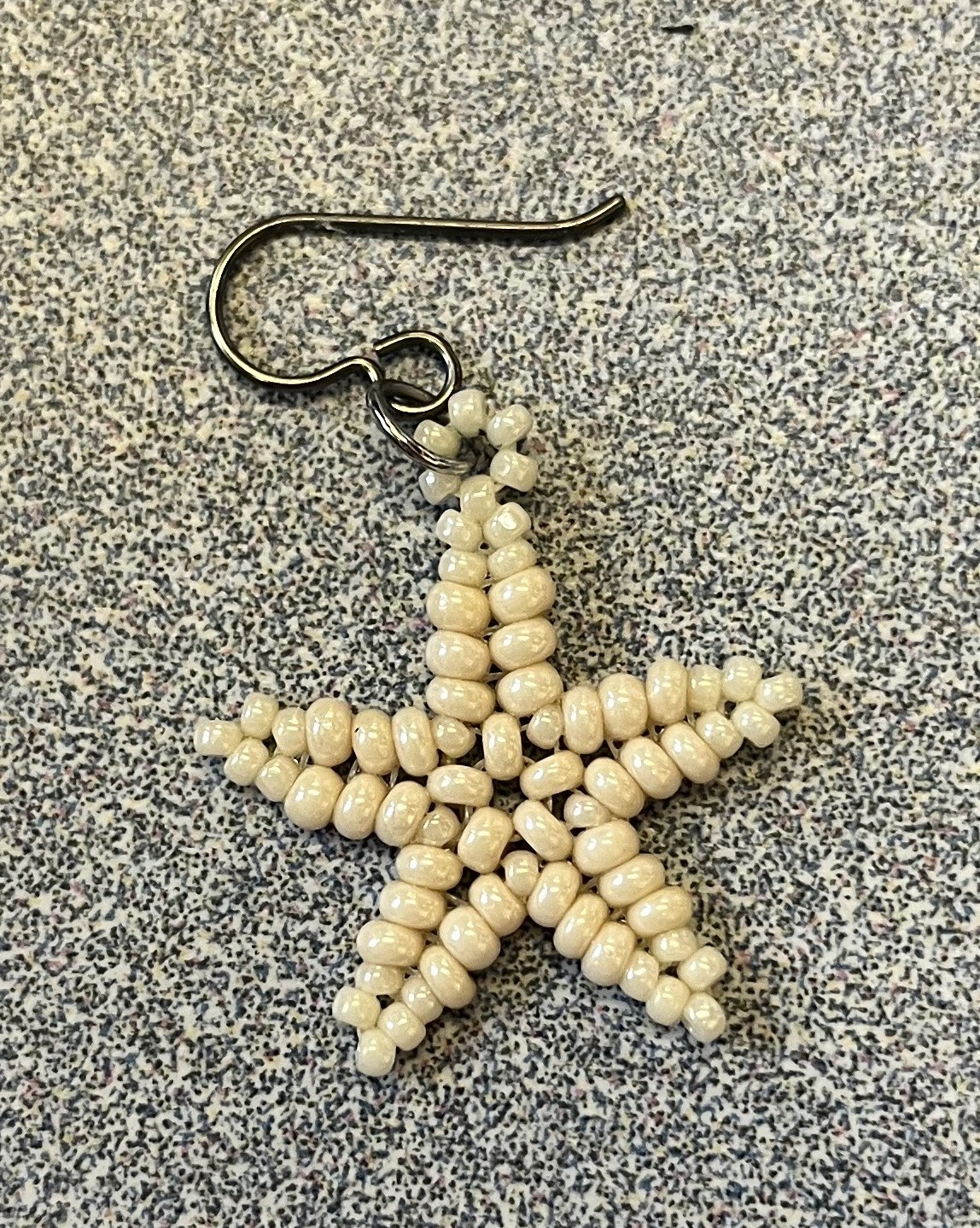 Star earring made from seed beads.